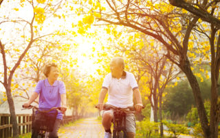 assisted living health and sunlight senior couple riding bikes