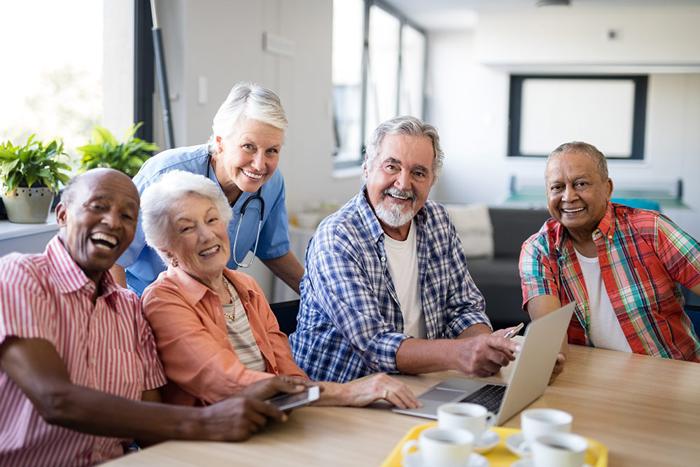 Group of seniors laughing and enjoying time together in senior living community