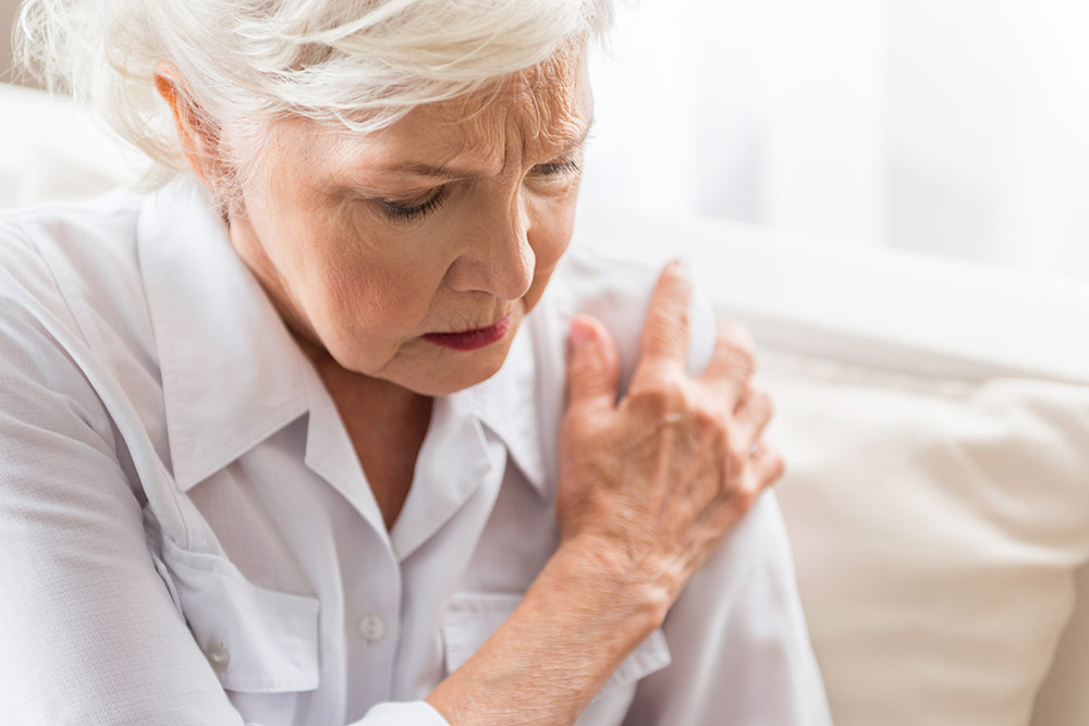 Senior woman holding shoulder, joint pain