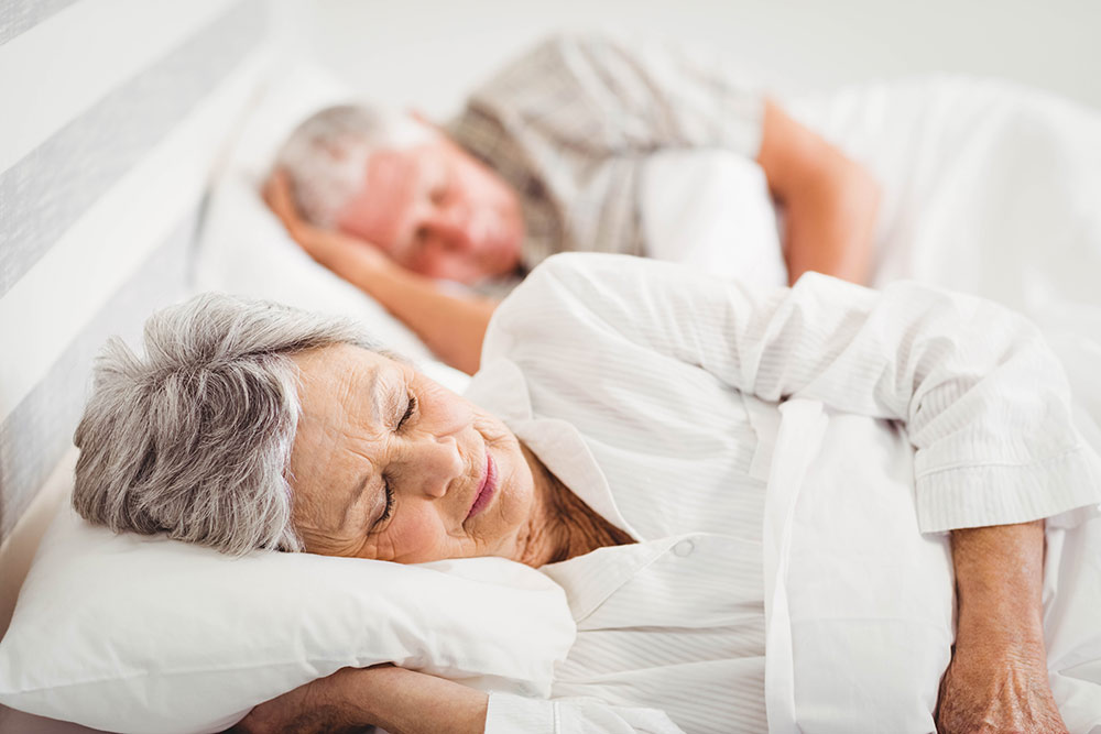 Senior couple sleeping in bed