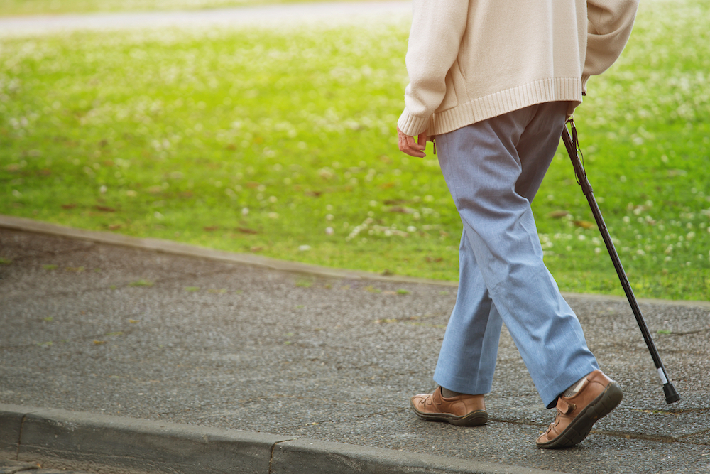 A senior man out on a walk with his cane