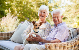 A senior couple sitting outside with the dog
