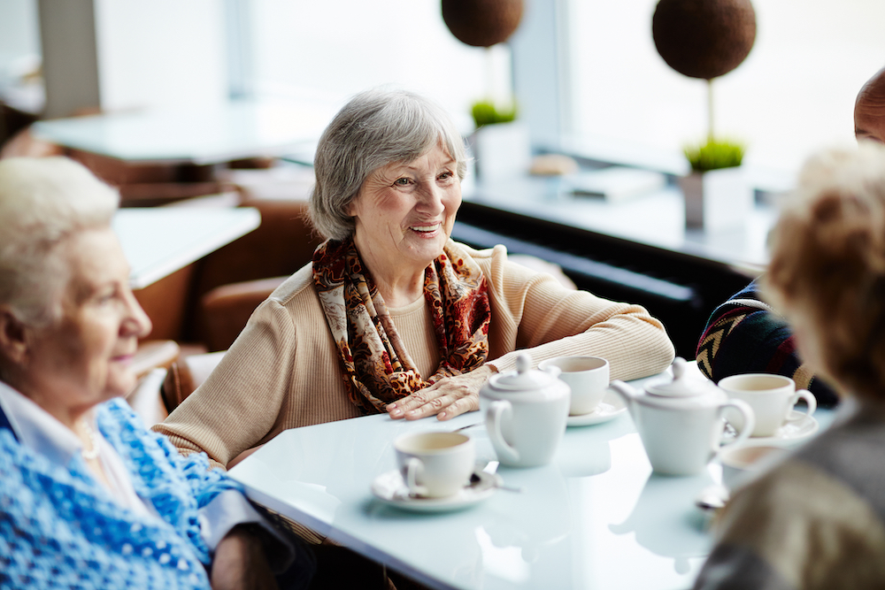 A group of senior women sit an enjoy tea together at assisted living in Macomb County