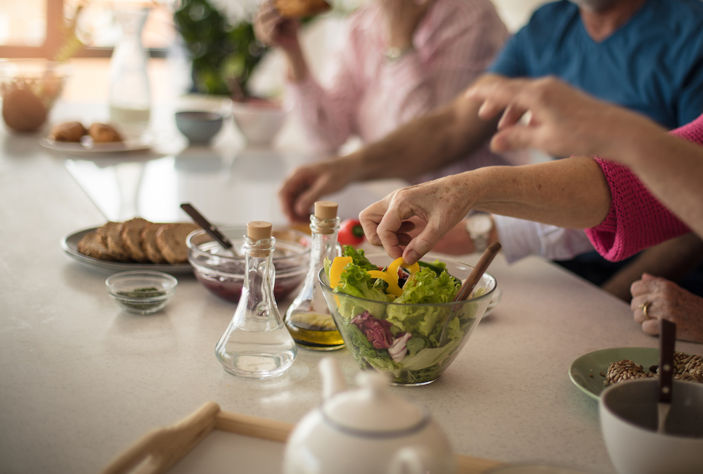 A group of seniors eating a healthy dinner with a salad