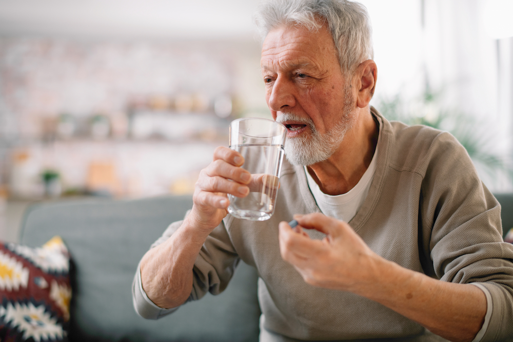 A senior man taking a vitamin D supplement 