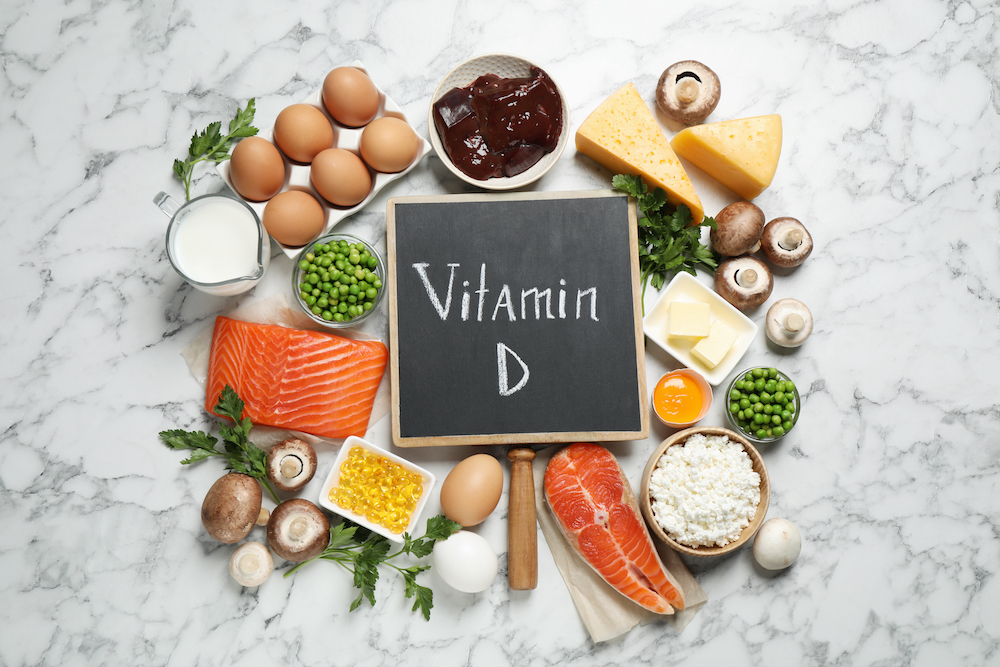 A chalkboard sign that reads 'Vitamin D' while surrounded by healthy foods