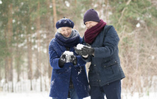 A senior couple at the retirement communities near me playing in the snow