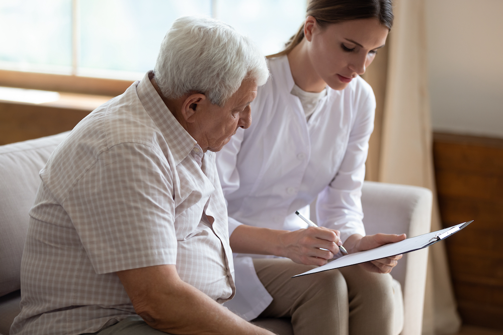 A senior man and his caregiver work together to draw up an emergency plan