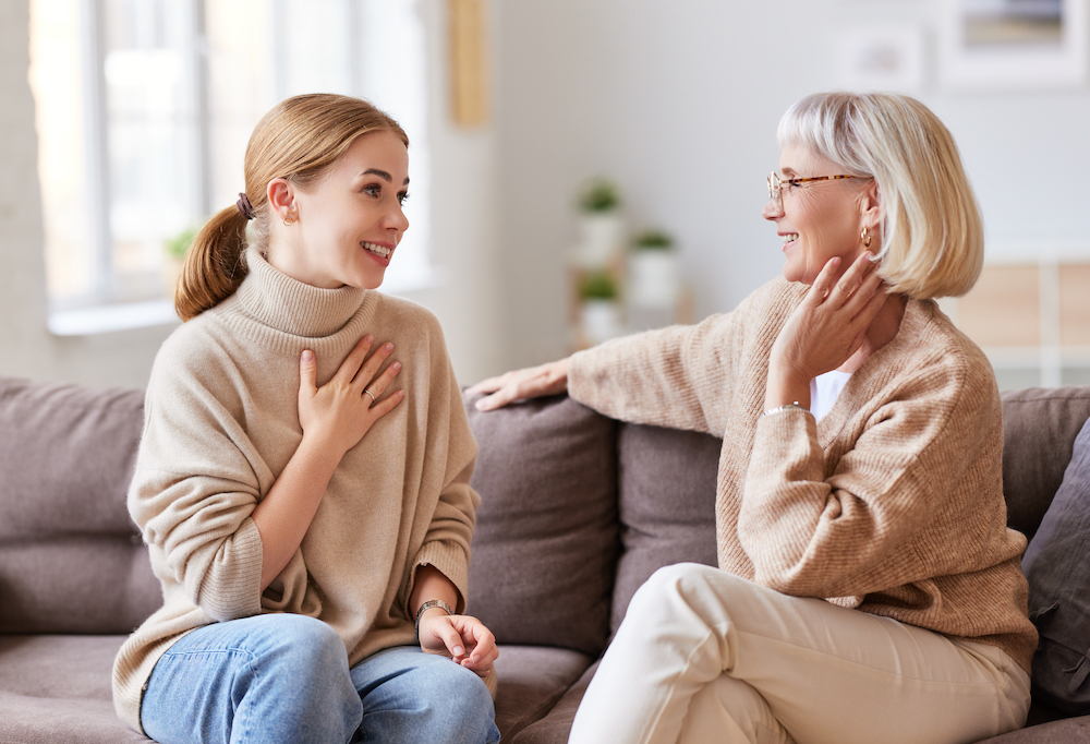 A young woman and her senior mother sit and talk about moving to the assisted living facilities near me