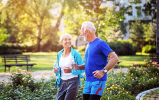 A happy senior couple goes for a jog outdoors at a park