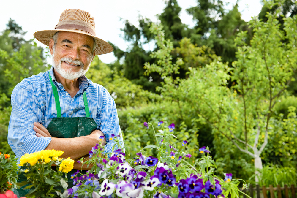 A resident of the best assisted living in Michigan stands out in his flower garden