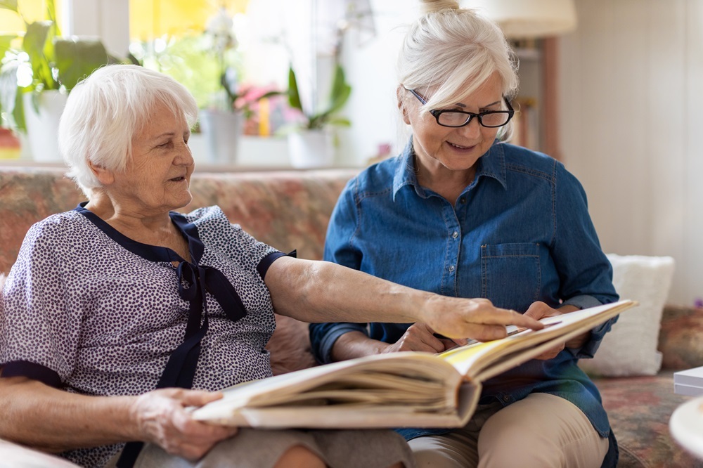 Senior friends looking through a photo book at the senior living near me