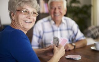 A senior woman and her friend play a game of cards together