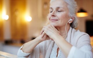 A senior woman listening to music on her headphones