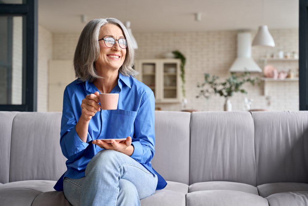 Happy senior drinking coffee in retirement communities near me.