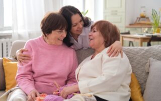 Senior woman with adult daughter and granddaughter enjoying their time together at memory care macomb mi