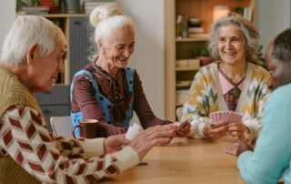 Group of senior friends playing cards at their senior living communities